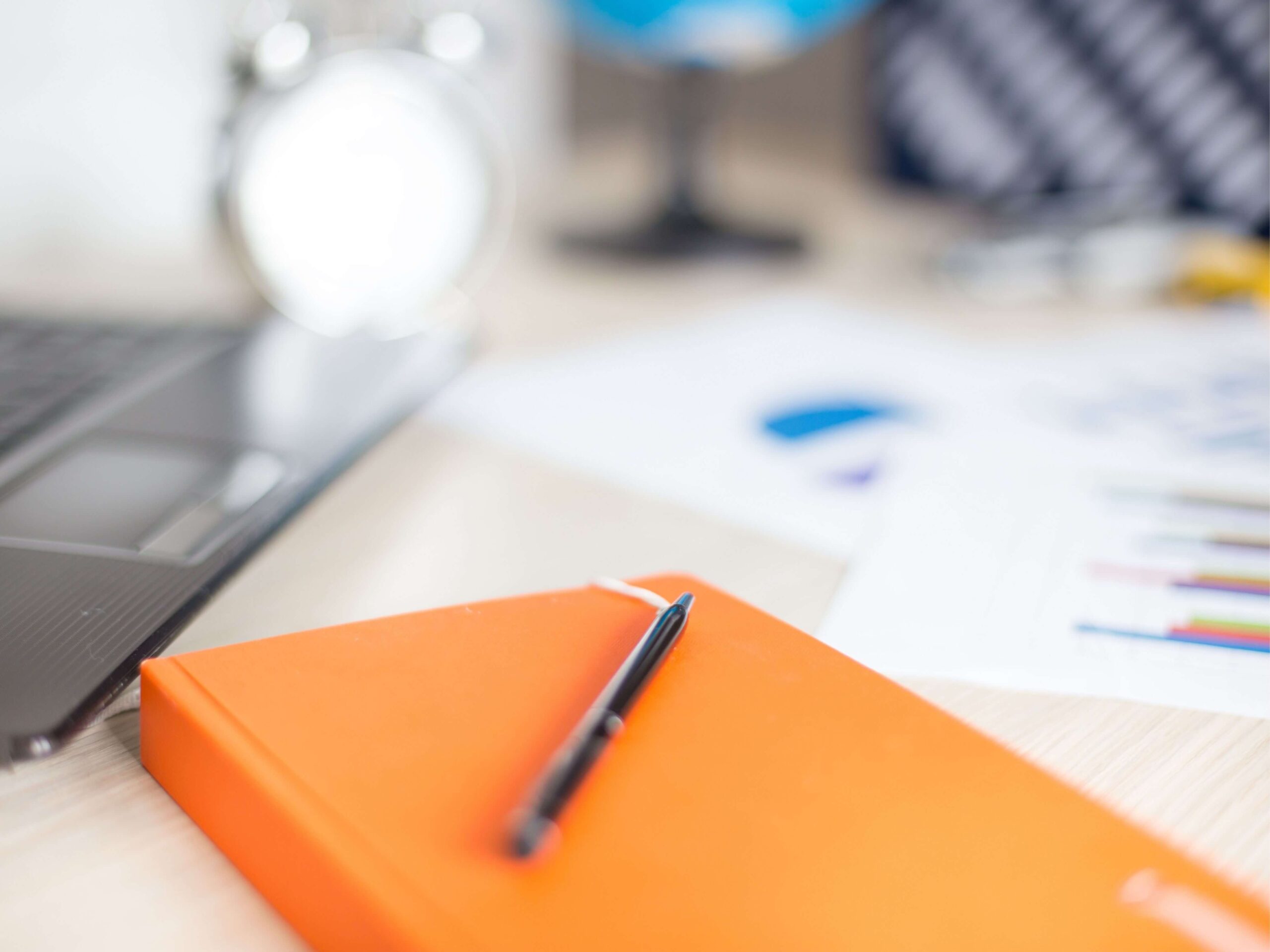 seo consulting services, image of an orange notebook with a pen on top of it